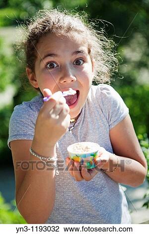 幸せ 若い 女の子 アイスクリームを食べること から A カップ ストックイメージ Yn3 Fotosearch