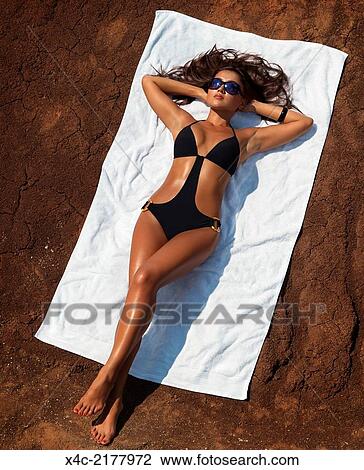 美しい セクシー 日焼けした 女性が日光浴をする あること 上に A 浜 タオル 上に 赤 Soil ストックイメージ X4c Fotosearch