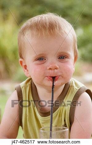 1 year old baby boy smiling cheekily into camera, outside on a sunny day, with a straw in his mouth View Large Photo Image Stock Photo - 1 year old baby boy smiling cheekily into camera, outside on a sunny day, with a straw in his mouth. Fotosearch