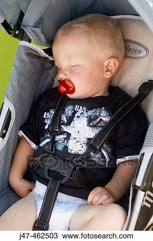 1 year old boy asleep in the pram with a dummy in his mouth. View Large Photo Image Stock Image - 1 year old boy asleep in the pram with a dummy in his mouth.. Fotosearch