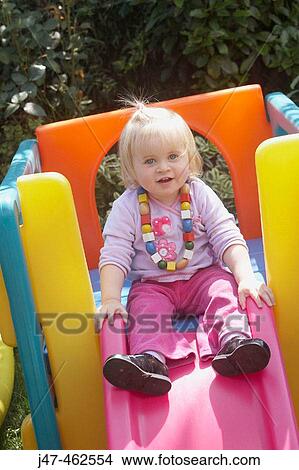 1 year old girl sitting at the top of a slide smiling into camera View Large Photo Image Picture - 1 year old girl sitting at the top of a slide smiling into camera. Fotosearch