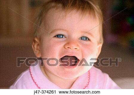 Stock Image - 10 month old baby girl laughing. Fotosearch