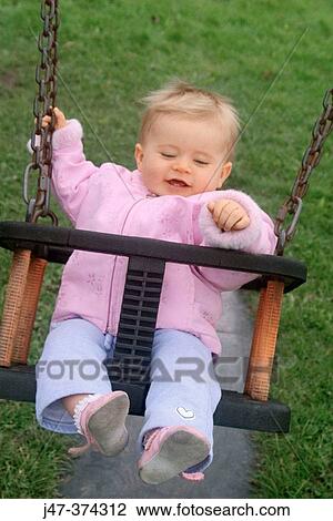 10 month old baby girl swinging in park smiling View Large Photo Image Stock Image - 10 month old baby girl swinging in park smiling. Fotosearch