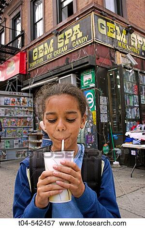 10-year-old biracial girl drinking an egg cream in front of a traditional fountain shop in the East Village. New York City. USA. View Large Photo Image Stock Photo - 10-year-old biracial girl drinking an egg cream in front of a traditional fountain shop in the East Village. New York City. USA.. Fotosearch