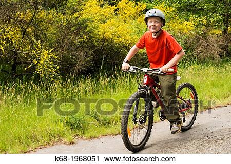 Stock Image - 10 year old boy bicycling on Saturna Island, Gulf Islands, BC, Canada. Fotosearch