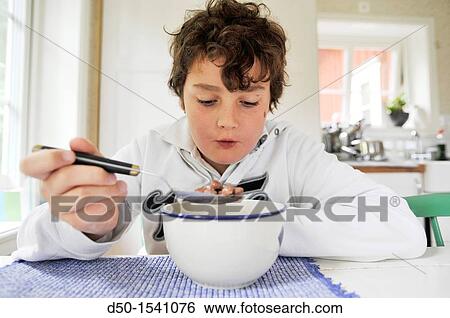 Stock Photograph - 10 year old boy eats coco puffs for breakfast, Medevi, Sweden. Fotosearch