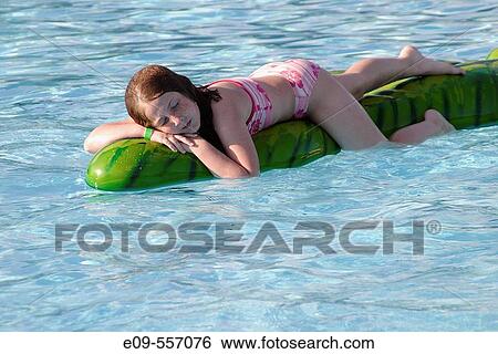 10-year-old girl in pink-and-white two-piece swimsuit lying contentedly on a floating plastic animal in a public swimming pool, in sunshine -- Bloomington, Indiana, U. S. A. -- horizontal View Large Photo Image Stock Photograph - 10-year-old girl in pink-and-white two-piece swimsuit lying contentedly on a floating plastic animal in a public swimming pool, in sunshine -- Bloomington, Indiana, U. S. A. -- horizontal. Fotosearch