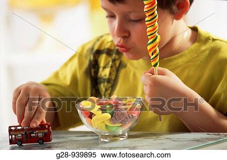 Stock Photography - 10 yeas old boy with candies, obesity. Fotosearch