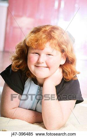 11 Year Old Girl Lying On Her Tummy Smiling Into Camera With