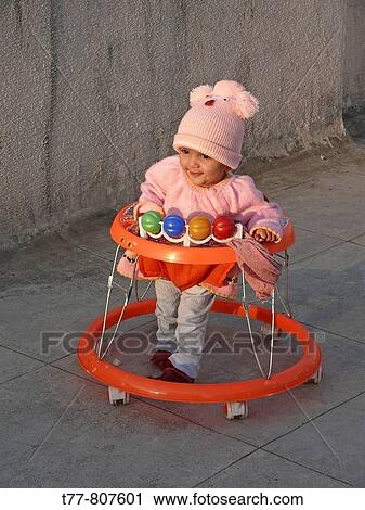 12 month old baby girl playing in a walker, with smile on face Pune, Maharashtra, India View Large Photo Image Stock Image - 12 month old baby girl playing in a walker, with smile on face Pune, Maharashtra, India. Fotosearch