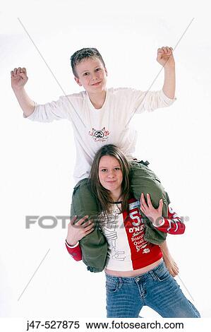 12 year old boy sitting on his sisters shoulders in the studio, arms in the air, delighted View Large Photo Image Stock Photography - 12 year old boy sitting on his sisters shoulders in the studio, arms in the air, delighted. Fotosearch