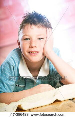 13 year old boy lying on his tummy, head resting on his hand, smiling into camera View Large Photo Image Stock Image - 13 year old boy lying on his tummy, head resting on his hand, smiling into camera. Fotosearch