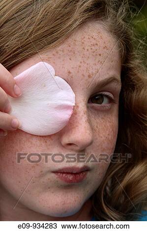 13-year-old girl with blonde-brown hair and freckles, holding a pink-white rose petal over her right eye, looking at camera, a somewhat arch and knowing expression View Large Photo Image Stock Image - 13-year-old girl with blonde-brown hair and freckles, holding a pink-white rose petal over her right eye, looking at camera, a somewhat arch and knowing expression. Fotosearch