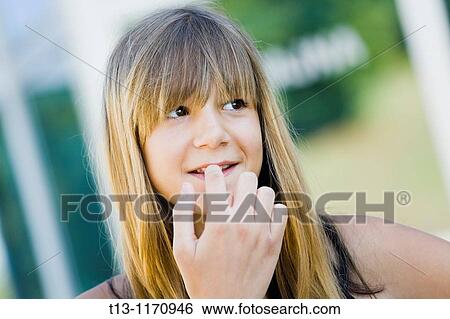 Stock Photograph - 15 year old girl portrait biting her fingernail. Fotosearch