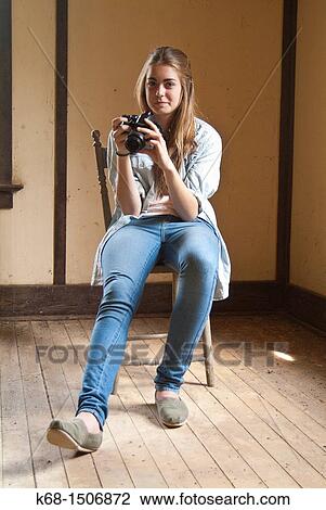 Stock Image - 15 year old girl sits in an old abandoned house. Fotosearch
