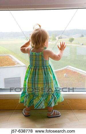 16 month old girl playing at a window in a hotel room overlooking a field and highway. View Large Photo Image Stock Photo - 16 month old girl playing at a window in a hotel room overlooking a field and highway.. Fotosearch