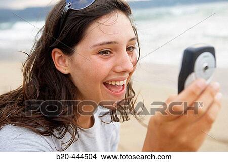 16 year old teengirl using cell phone at beach View Large Photo Image Picture - 16 year old teengirl using cell phone at beach. Fotosearch
