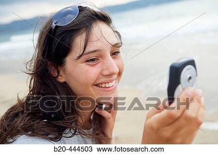 16 year old teengirl using cell phone at beach View Large Photo Image Stock Image - 16 year old teengirl using cell phone at beach. Fotosearch