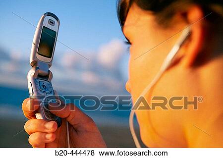 Stock Photo - 16 years old teenager listening to music in a MP3 mobile phone. Hendaye beach. Aquitaine. France.. Fotosearch