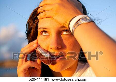 Stock Image - 16 years old teenager talking on a mobile phone. Hendaye beach. Aquitaine. France.. Fotosearch