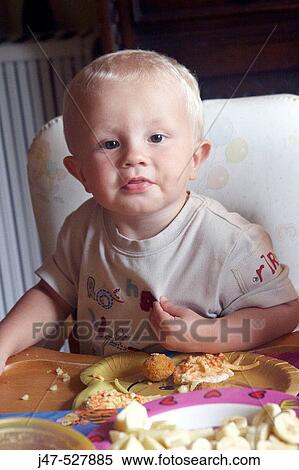 18 month old boy, gazing into camera in front of plates of food at a party View Large Photo Image Stock Photography - 18 month old boy, gazing into camera in front of plates of food at a party. Fotosearch