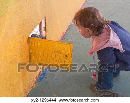 18 month old child looking into open water meter box in Torremolinos Spain View Large Photo Image Picture - 18 month old child looking into open water meter box in Torremolinos Spain. Fotosearch