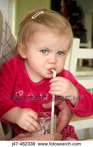18 month old girl drinking through a straw looking straight into camera View Large Photo Image Stock Photo - 18 month old girl drinking through a straw looking straight into camera. Fotosearch
