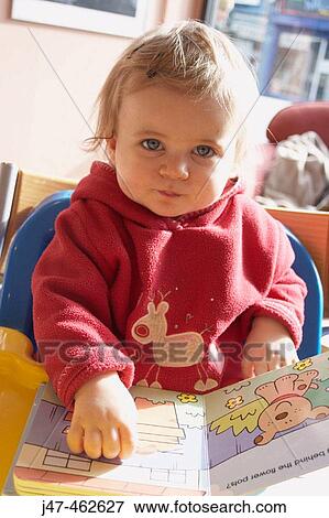 18 month old girl in a cafe looking at a book View Large Photo Image Stock Photo - 18 month old girl in a cafe looking at a book. Fotosearch