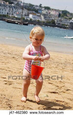 18 month old girl on the beach carrying a bucket of water View Large Photo Image Stock Image - 18 month old girl on the beach carrying a bucket of water. Fotosearch