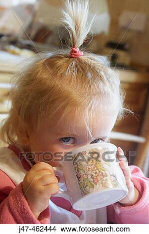 18 month old girl sitting having a drink looking into camera View Large Photo Image Picture - 18 month old girl sitting having a drink looking into camera. Fotosearch