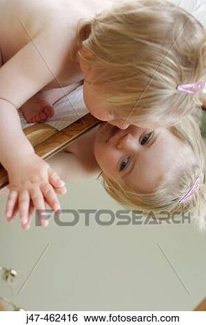 18 month old girl sitting looking at herself in a mirror View Large Photo Image Stock Photograph - 18 month old girl sitting looking at herself in a mirror. Fotosearch