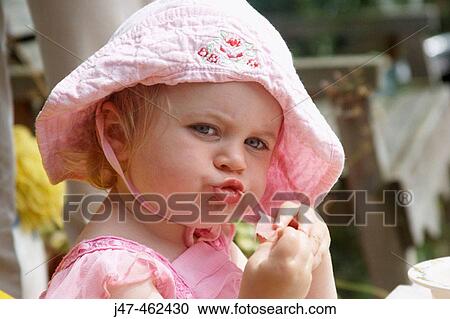 18 month old girl sitting outside eating looking into the camera View Large Photo Image Stock Image - 18 month old girl sitting outside eating looking into the camera. Fotosearch