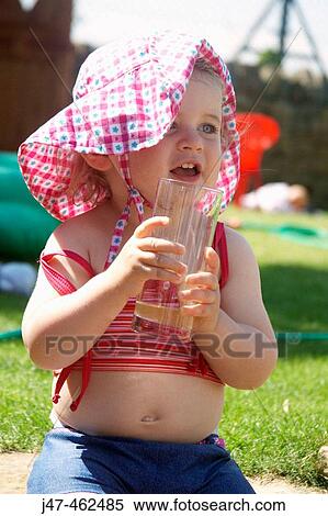 18 month old girl sitting outside holding a drink smiling off camera View Large Photo Image Stock Photography - 18 month old girl sitting outside holding a drink smiling off camera. Fotosearch