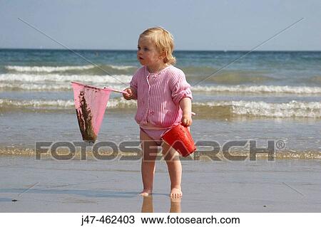 18 month old girl sitting standing on the bach with a fishing rod and bucket View Large Photo Image Stock Image - 18 month old girl sitting standing on the bach with a fishing rod and bucket. Fotosearch
