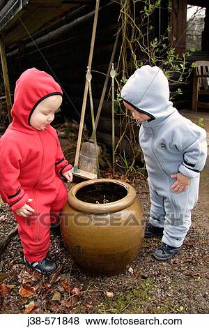 Stock Photo - 18 month old twin boys playing with water, Germany. Fotosearch