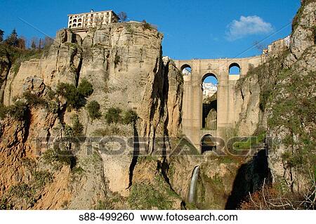 Stock Image - 18th century Puente Nuevo. On the leftside on top of the rock is Hotel Parador.. Fotosearch