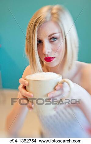 Picture - 19 year old blond woman holding an oversize coffee cup. Fotosearch