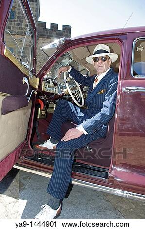 Stock Image - 1940 style US government agent in a 1942 Chrysler New Yorker car. Fotosearch