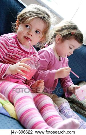 2, 3 year old girls drinking juice through a straw, looking off camera View Large Photo Image Stock Image - 2, 3 year old girls drinking juice through a straw, looking off camera. Fotosearch