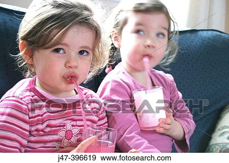 2, 3 year old girls drinking juice through a straw, looking off camera View Large Photo Image Stock Photo - 2, 3 year old girls drinking juice through a straw, looking off camera. Fotosearch