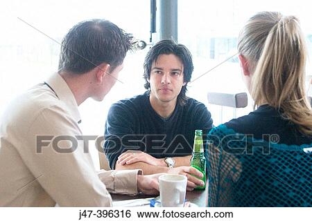 2 men and a girl talking over a drink in a cafe View Large Photo Image Stock Photograph - 2 men and a girl talking over a drink in a cafe. Fotosearch
