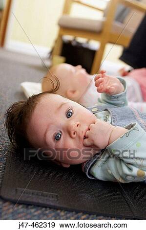 2 month old baby lying on her back looking into camera, with her fingers in her mouth View Large Photo Image Stock Photo - 2 month old baby lying on her back looking into camera, with her fingers in her mouth. Fotosearch