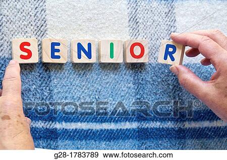 Stock Photo - 2 senior woman s? hands and fingers using letters of a game to write the word senior. Fotosearch
