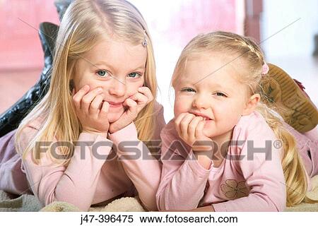 2 sisters, 5 and 3, lying on the floor head in hands smiling at camera View Large Photo Image Stock Photography - 2 sisters, 5 and 3, lying on the floor head in hands smiling at camera. Fotosearch