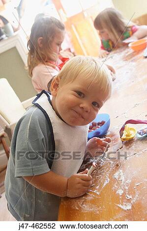 2 year od boy smiling into camera whilst baking with his friends View Large Photo Image Stock Image - 2 year od boy smiling into camera whilst baking with his friends. Fotosearch