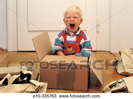 Stock Image - 2 year old boy in a box crying. Fotosearch
