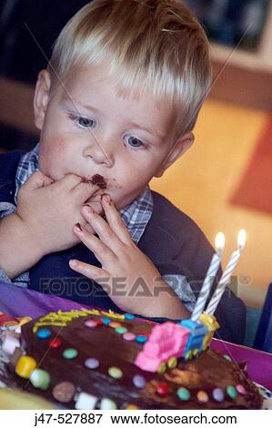 2 year old boy, looking at his birthday cake with chocolate round his mouth, eating chocolate View Large Photo Image Stock Photo - 2 year old boy, looking at his birthday cake with chocolate round his mouth, eating chocolate. Fotosearch