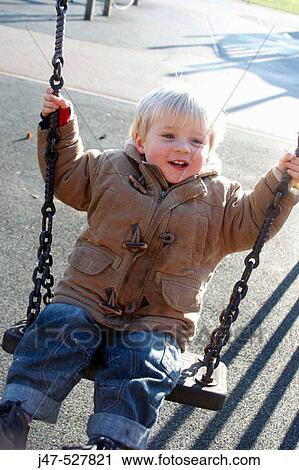 2 year old boy, on a swing in the park smiling off camera View Large Photo Image Stock Image - 2 year old boy, on a swing in the park smiling off camera. Fotosearch