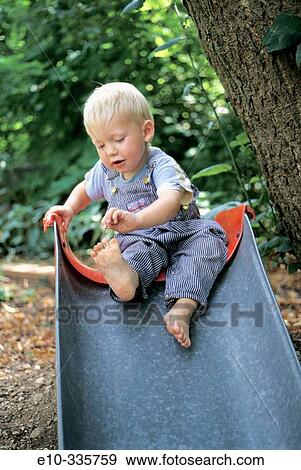 Stock Photo - 2 year old boy on slide. Fotosearch