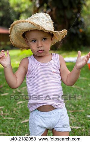 Stock Photo - 2 year old boy outdoors with cowboy hat.. Fotosearch